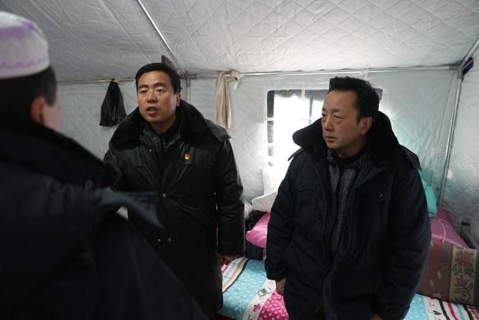 2023年12月22日，積石山縣大河家鎮(zhèn)大河村黨支部書記馬成忠（右二）在帳篷里和受災(zāi)群眾交流。新華社記者 陳斌 攝