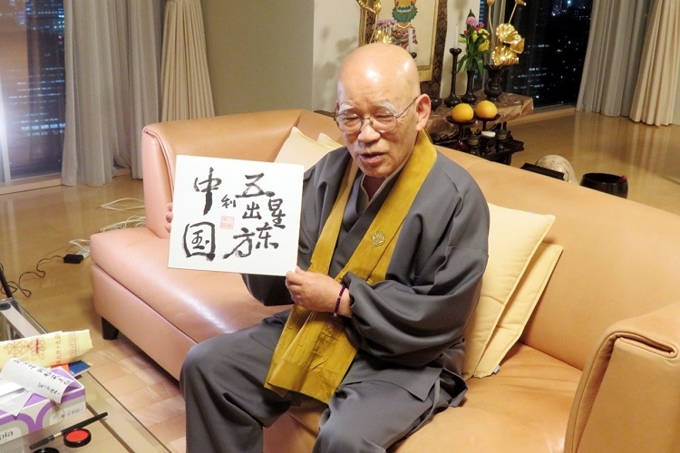 小島康譽展示自己書寫的“五星出東方利中國”。視頻截圖