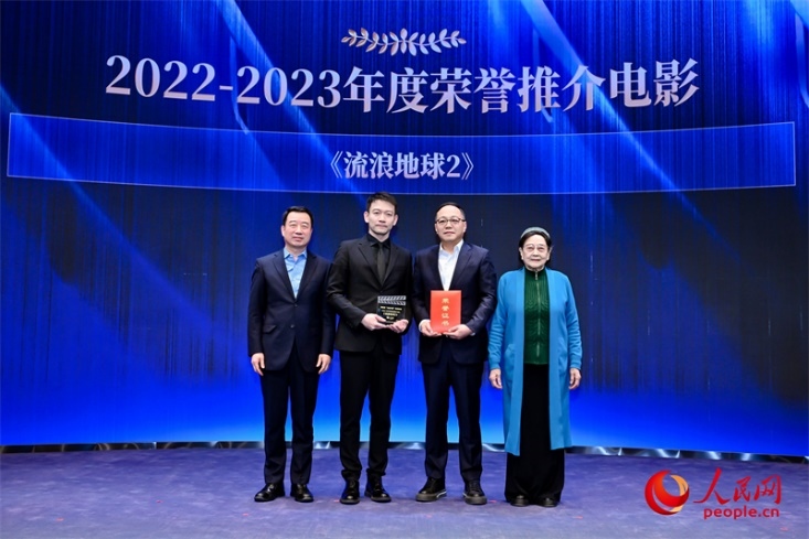 著名電影藝術(shù)家、事業(yè)家王曉棠（右一）和中國文聯(lián)書記處書記張宏（左一）為《流浪地球2》出品人、總監(jiān)制、總制片人傅若清（右二）與導(dǎo)演郭帆（左二）頒發(fā)“2022-2023年度榮譽推介電影”