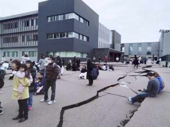  1月1日，在日本石川縣輪島市，人們站在被地震破壞的地面上。新華社/共同社