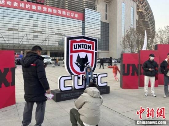 球迷們與隊(duì)徽合影。記者 卞立群 攝