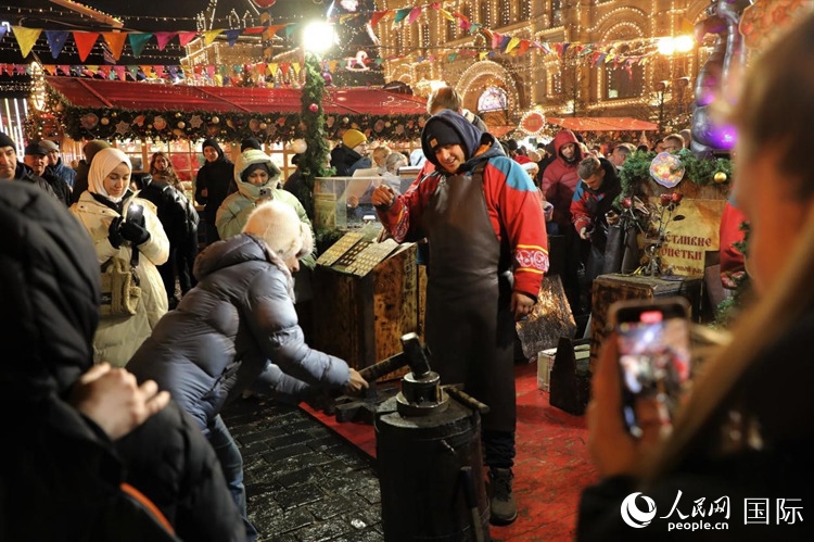 游客在新年集市上體驗制作紀念幣。人民網(wǎng)記者 隋鑫攝