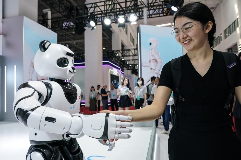 2023年8月16日，一名女士在北京舉辦的2023世界機(jī)器人大會(huì)現(xiàn)場(chǎng)與智能機(jī)器人握手。新華社記者彭子洋攝