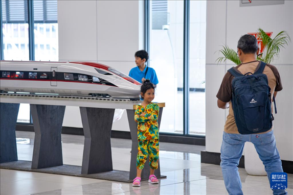 1月24日，在印度尼西亞雅加達(dá)哈利姆站候車大廳，一名小朋友和雅萬高鐵高速動(dòng)車組模型合影。新華社記者 徐欽 攝