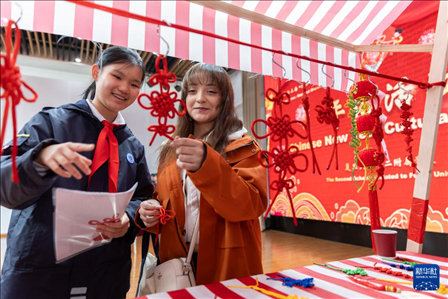 1月28日，復(fù)旦大學(xué)第二附屬學(xué)校學(xué)生（左）為美國馬斯卡廷中學(xué)學(xué)生（右）介紹中國結(jié)。 新華社記者 王翔 攝