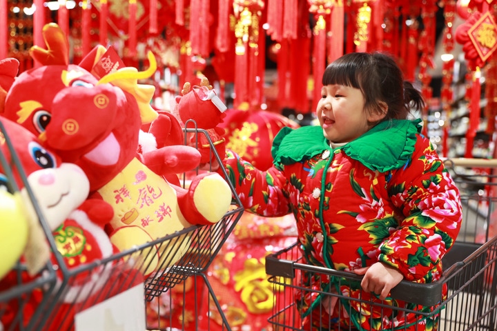 1月23日，在貴州省黔東南苗族侗族自治州岑鞏縣一家超市，小朋友在家人的帶領(lǐng)下選購(gòu)龍年毛絨玩具。新華社發(fā)（唐鵬攝）