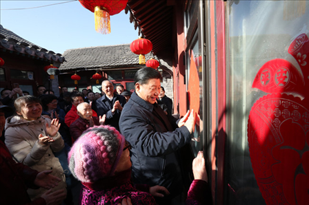 2019年2月1日上午，習近平總書記在前門東區(qū)草廠四條胡同32號院，高興地拿起一幅“?！弊郑H自貼到門上，給這里的老街坊們拜年。新華社記者鞠鵬攝