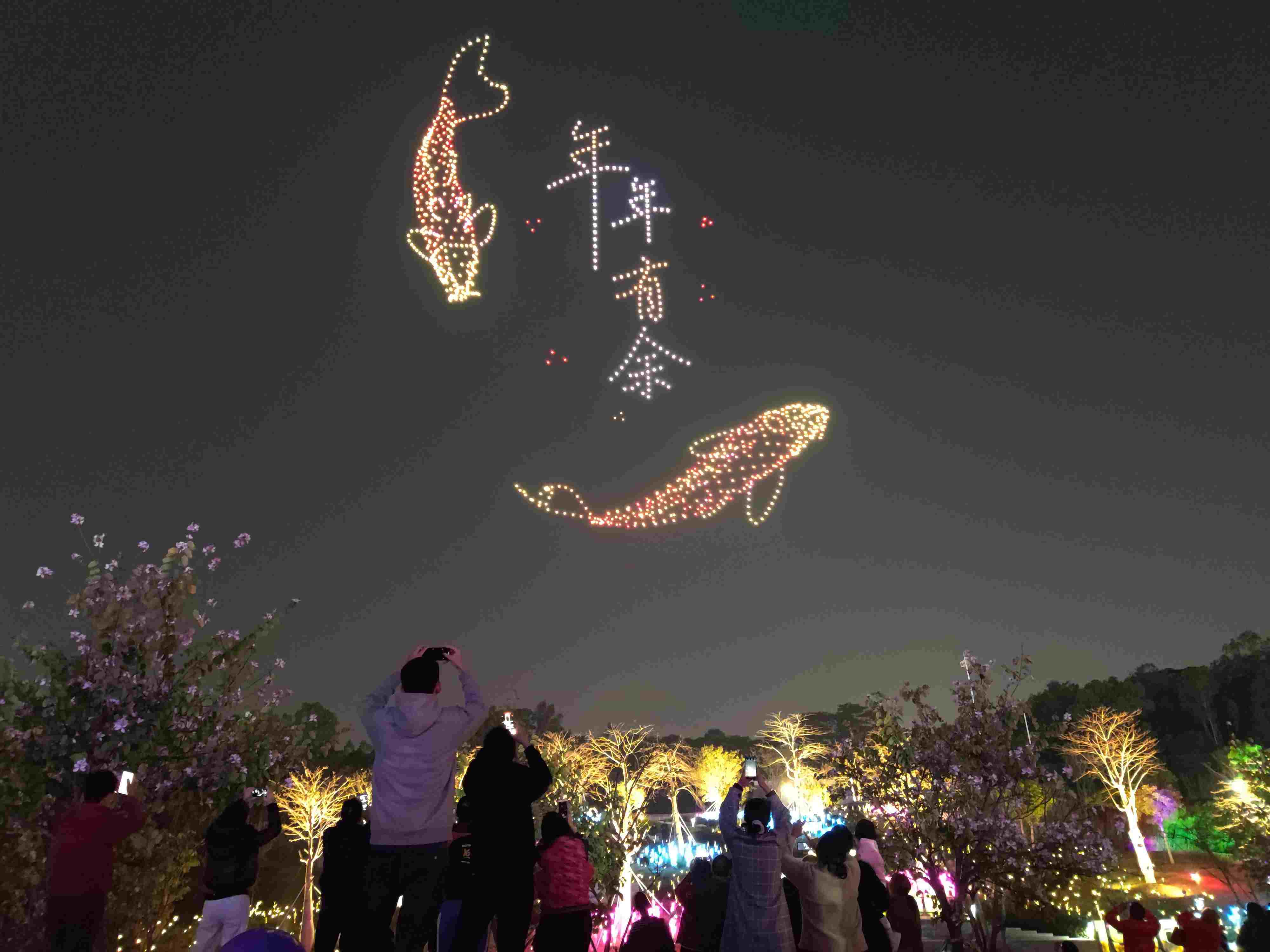 △ 2024年2月10日，深圳北站中心公園，春節(jié)主題無人機(jī)燈光秀引來眾多游客駐足觀看。