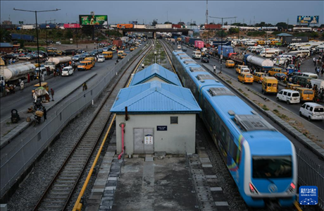 3月4日，在尼日利亞拉各斯，一列輕軌藍(lán)線列車行駛至公路交通擁堵路段附近。新華社記者 韓旭 攝