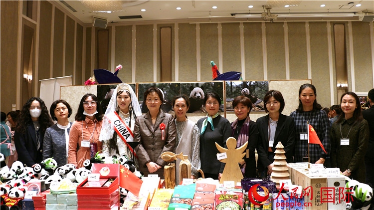 中國(guó)駐日本大使吳江浩夫人丁玥（左五）與使館人員在展位前合影留念。人民網(wǎng) 許可攝