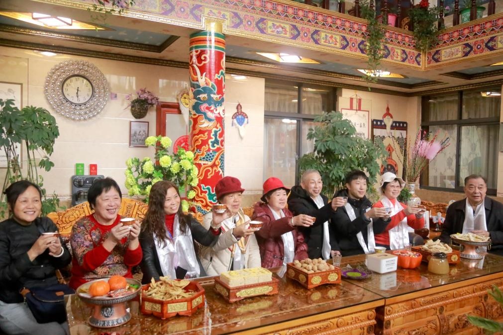 游客們?nèi)胱∶袼藓?，舉杯共飲酥油茶。新華社記者 邱星翔 攝