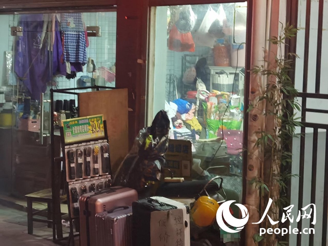南寧“城中村”一裁縫鋪老板將電線從店內(nèi)拉出為電動(dòng)自行車充電。人民網(wǎng) 覃心攝