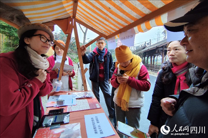 1月6日，“2024成都蒲江柑甜采摘節(jié)”上，記者見到了小萌（左一）和許多年輕人忙著做訪客接待、現(xiàn)場布置、票務(wù)核對、采摘服務(wù)等工作。人民網(wǎng)記者朱虹攝