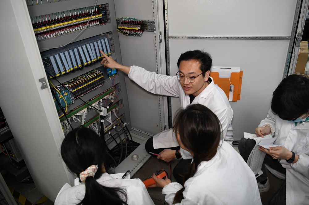 2024年4月6日，在位于安徽合肥的中國科學(xué)技術(shù)大學(xué)，安徽省先進功能高分子薄膜工程實驗室團隊成員在檢修自主研制的高分子薄膜原位雙向拉伸實驗設(shè)備的電氣控制系統(tǒng)。