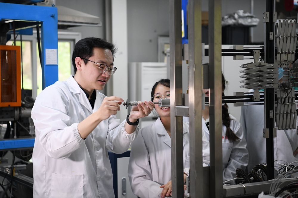2024年4月6日，在位于安徽合肥的中國科學(xué)技術(shù)大學(xué)，安徽省先進功能高分子薄膜工程實驗室團隊成員朱健和（左）在和同事討論實驗設(shè)備的設(shè)計方案。