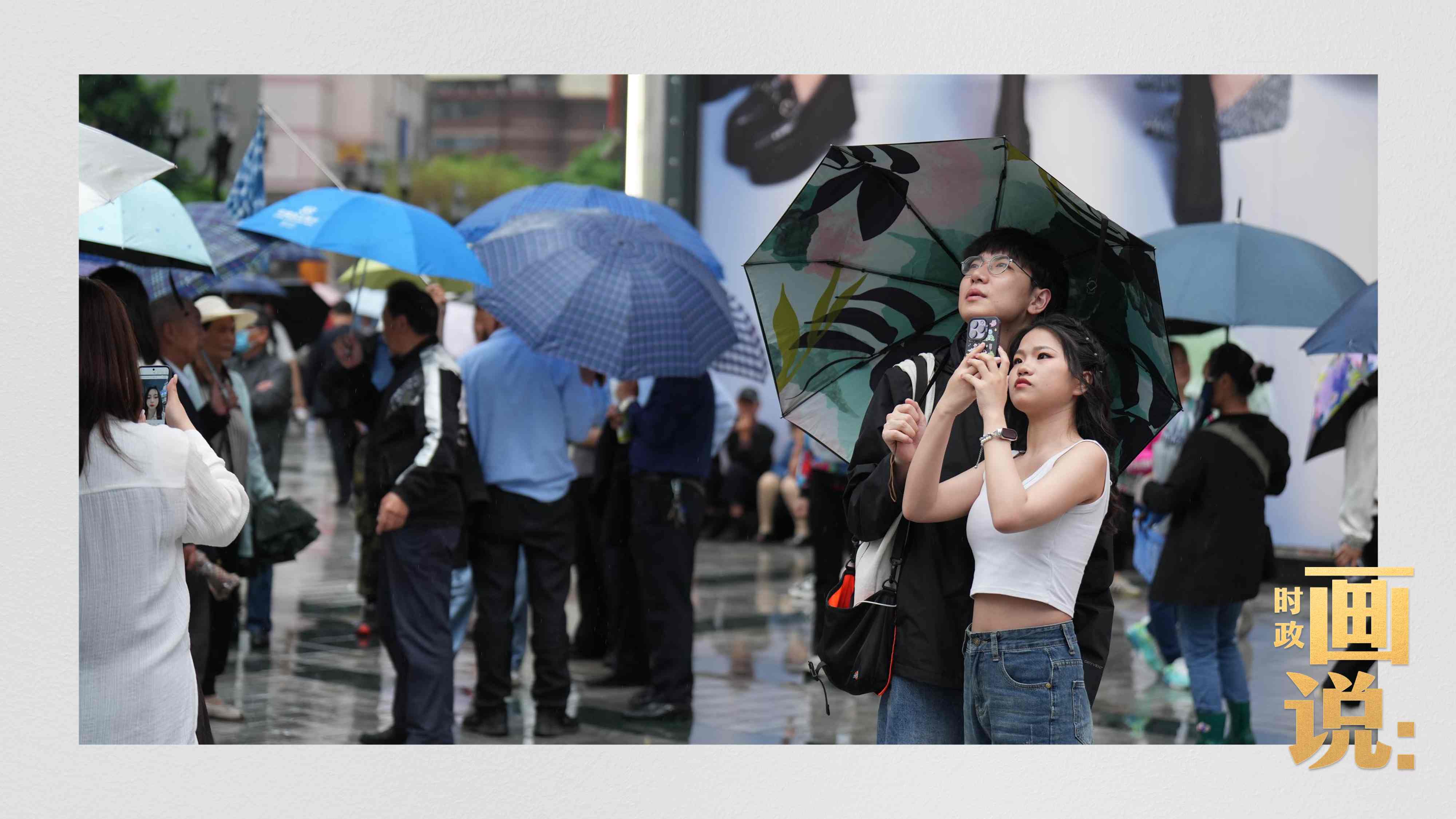 △細(xì)雨中的解放碑步行街，騎在父親肩膀的小女孩好奇張望。