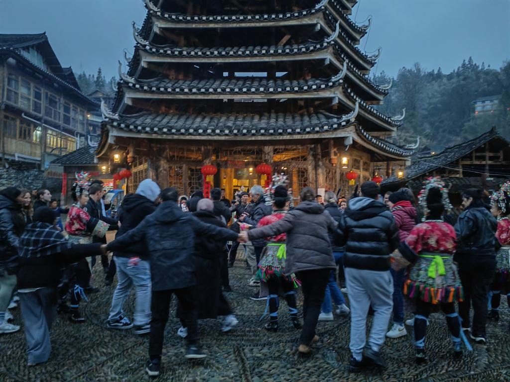 法國青年與當地村民牽手跳舞。新華社記者 羅羽 攝