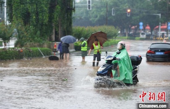 5月10日，廣西沿海遭遇強降雨。圖為欽州市民眾在積澇中出行。陸敏 攝