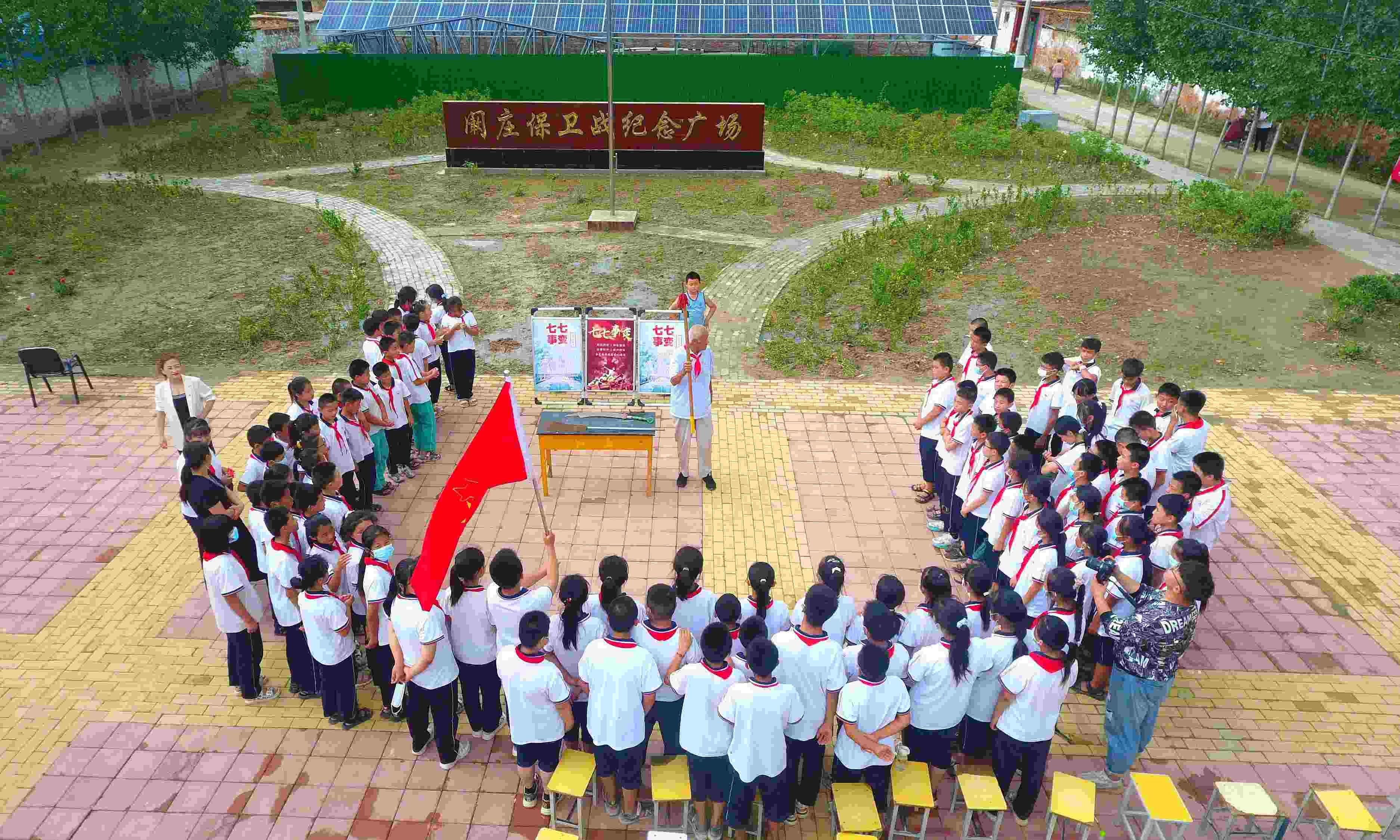 2022年7月6日，山東省聊城市，在茌平區(qū)菜屯鎮(zhèn)闞莊村的闞莊保衛(wèi)戰(zhàn)紀(jì)念廣場(chǎng)，闞莊保衛(wèi)戰(zhàn)親歷者王光木老人為小學(xué)生們講述抗戰(zhàn)故事，展示大刀、長(zhǎng)矛。