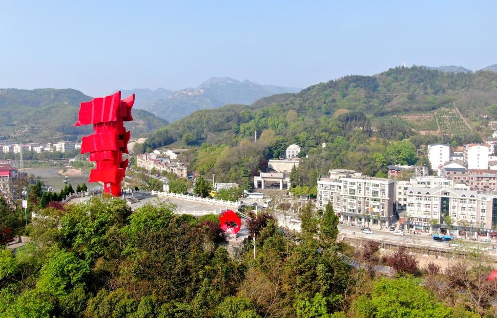 這是2021年4月9日拍攝的鄂豫皖蘇區(qū)首府革命博物館附近的英雄山上的“紅旗飄飄”主題雕塑（無人機照片）。新華社發(fā)