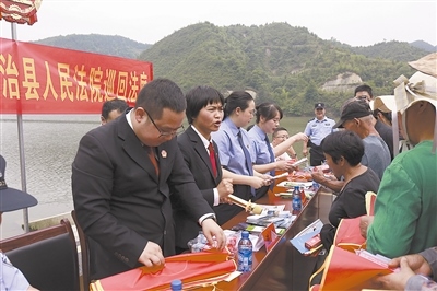 法院干警及相關(guān)部門(mén)工作人員對(duì)群眾進(jìn)行生態(tài)環(huán)境保護(hù)普法教育。