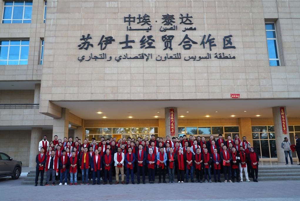 2024年2月11日，在位于埃及蘇伊士省的中?！ぬ┻_(dá)蘇伊士經(jīng)貿(mào)合作區(qū)，中埃員工在合作區(qū)辦公大樓前合影拜年。新華社發(fā)（泰達(dá)合作區(qū)供圖）
