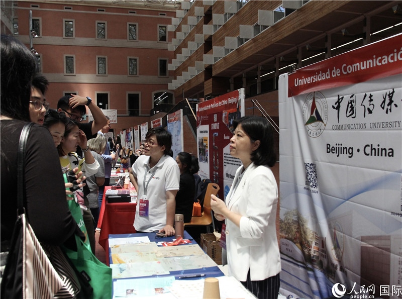 旅西華人華僑在展臺(tái)前咨詢。人民網(wǎng)記者 許海林?jǐn)z