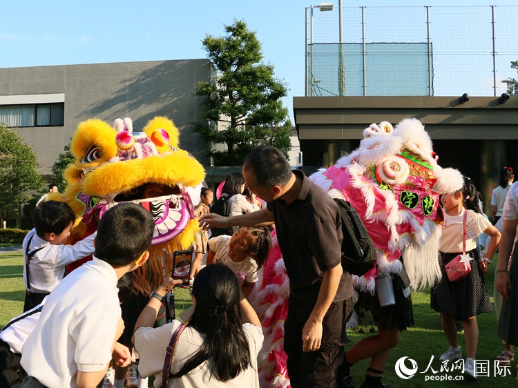 孩子們好奇地圍觀舞獅。人民網(wǎng) 許可攝