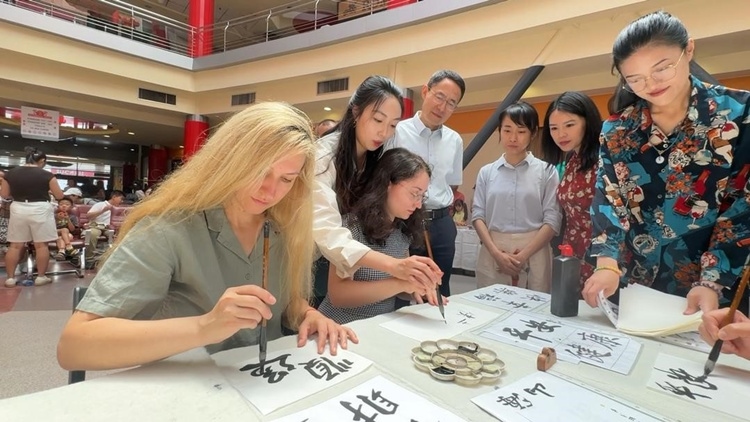 羅馬尼亞友人在活動現(xiàn)場學(xué)寫漢字。中國駐羅馬尼亞大使館領(lǐng)僑處供圖