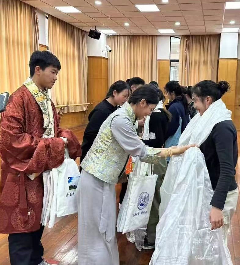 2024年1月18日，在上海市大同中學(xué)，果洛西寧民族中學(xué)學(xué)生給上海大同中學(xué)師生獻哈達。新華社發(fā)（果洛州教育局供圖）