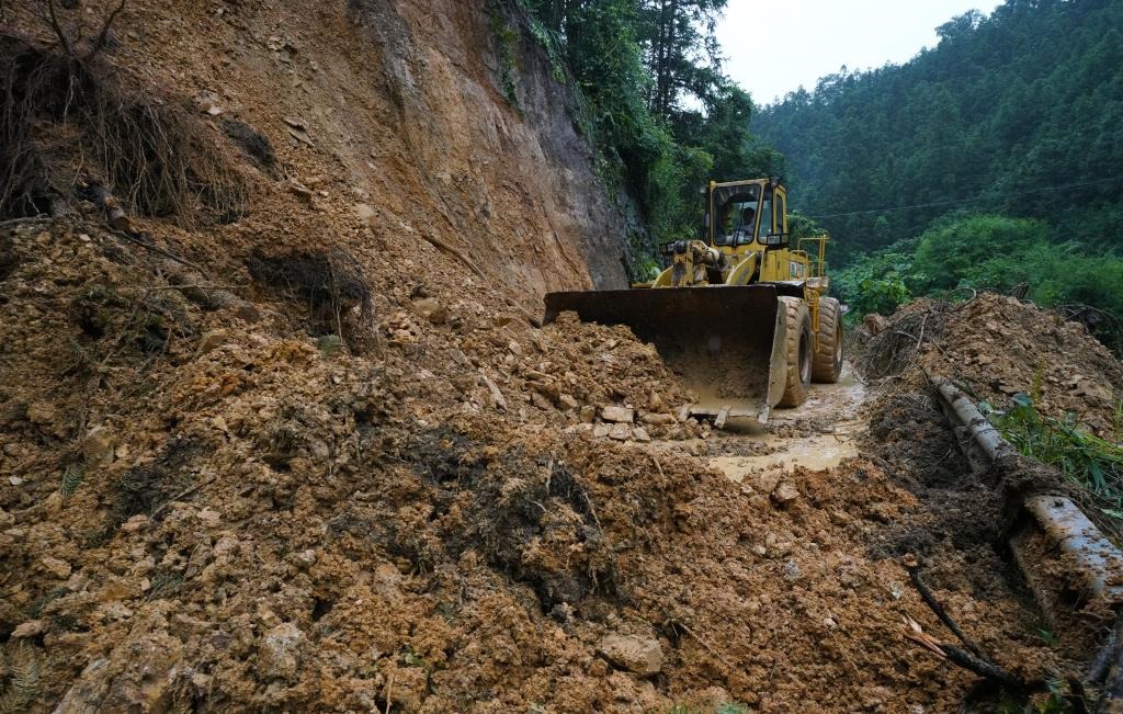 6月18日，在廣西融水苗族自治縣融水鎮(zhèn)新安村，一臺推土機在清理塌方路段。新華社發(fā)（龍林智攝）