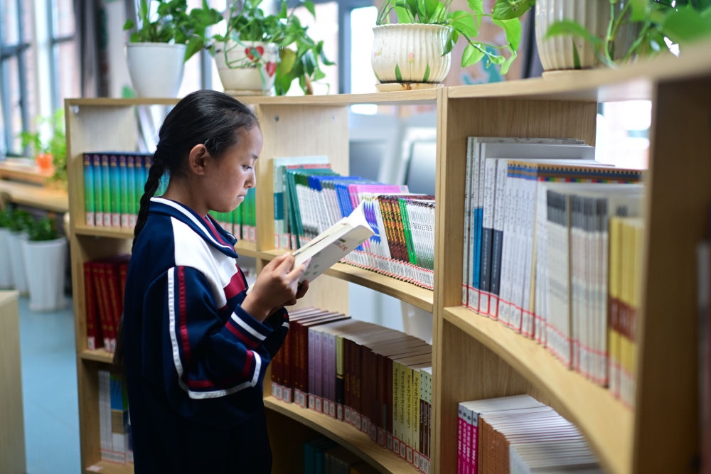6月18日，果洛西寧民族中學(xué)學(xué)生尼東拉毛在圖書室看書。