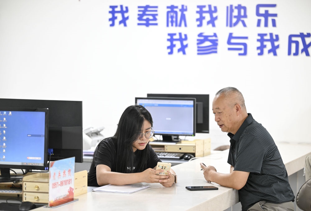 6月20日，在長(zhǎng)城花園社區(qū)黨群服務(wù)中心，工作人員幫助居民辦理業(yè)務(wù)。