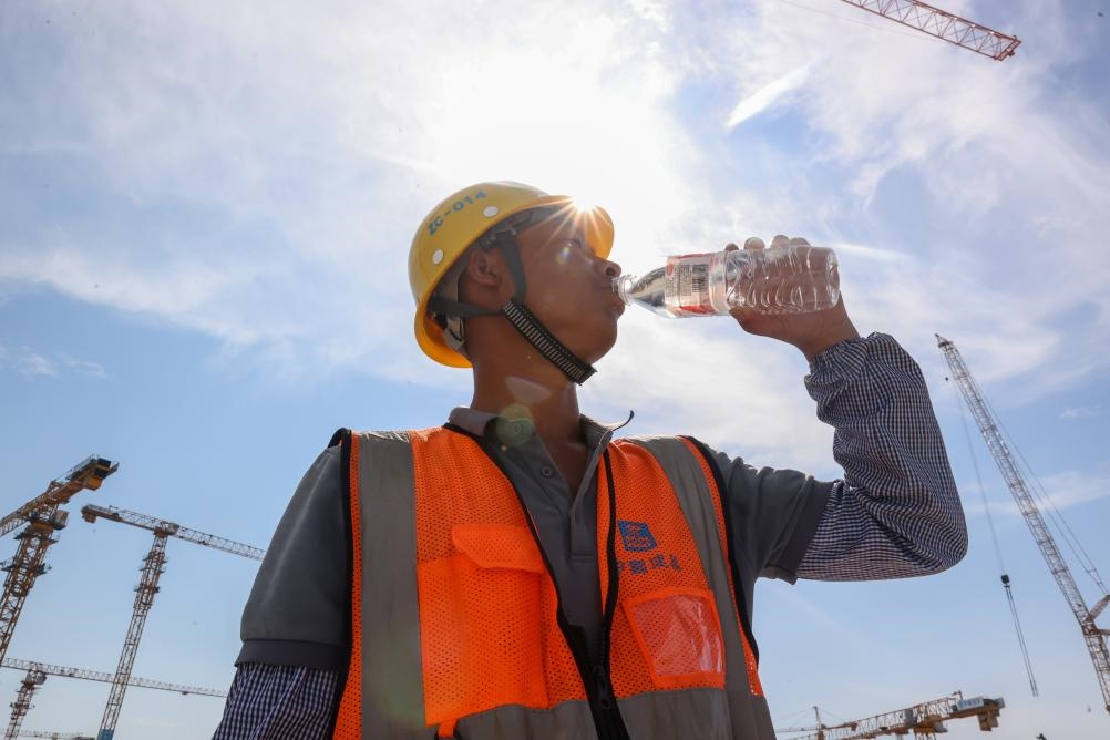 6月18日，在江蘇省無錫市奧體三期項目施工現(xiàn)場，中建二局工人在喝水解暑。新華社發(fā)（朱吉鵬 攝）