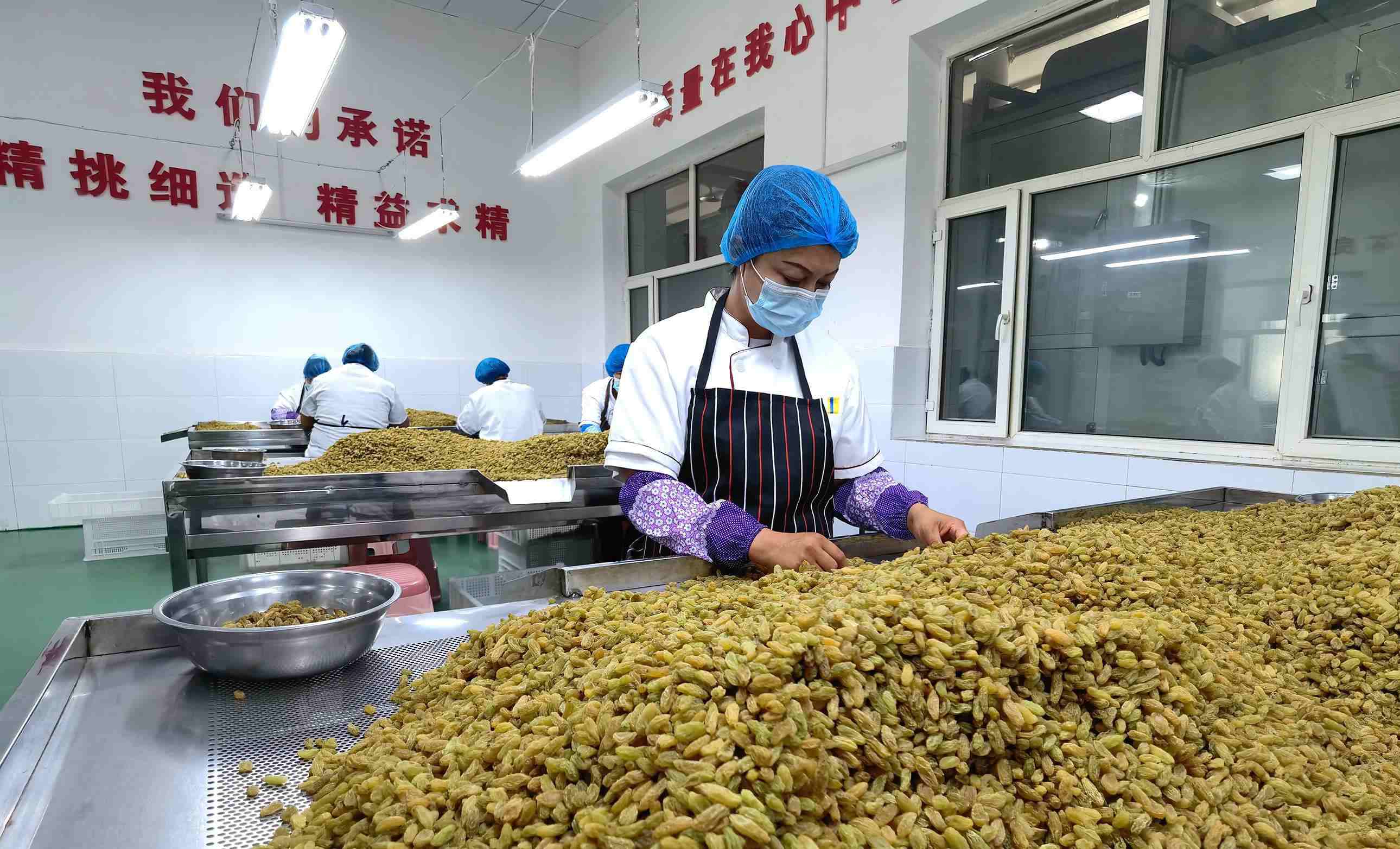 新疆吐魯番市高昌區(qū)亞爾鎮(zhèn)新城西門(mén)村，村民們?cè)诜謷咸迅伞? width=