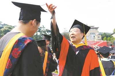 2017年6月22日，李德仁（右一）參加武漢大學(xué)畢業(yè)典禮并為畢業(yè)生撥穗。