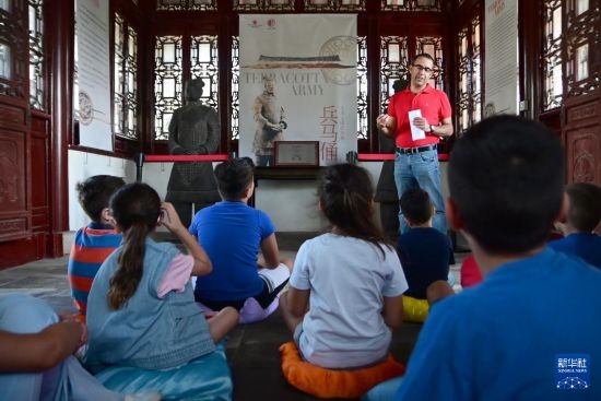 7月4日，在馬耳他桑塔露琪亞市的中國古典園林“靜園”，人們聆聽關(guān)于兵馬俑的講解。新華社發(fā)（喬納森·博格 攝）