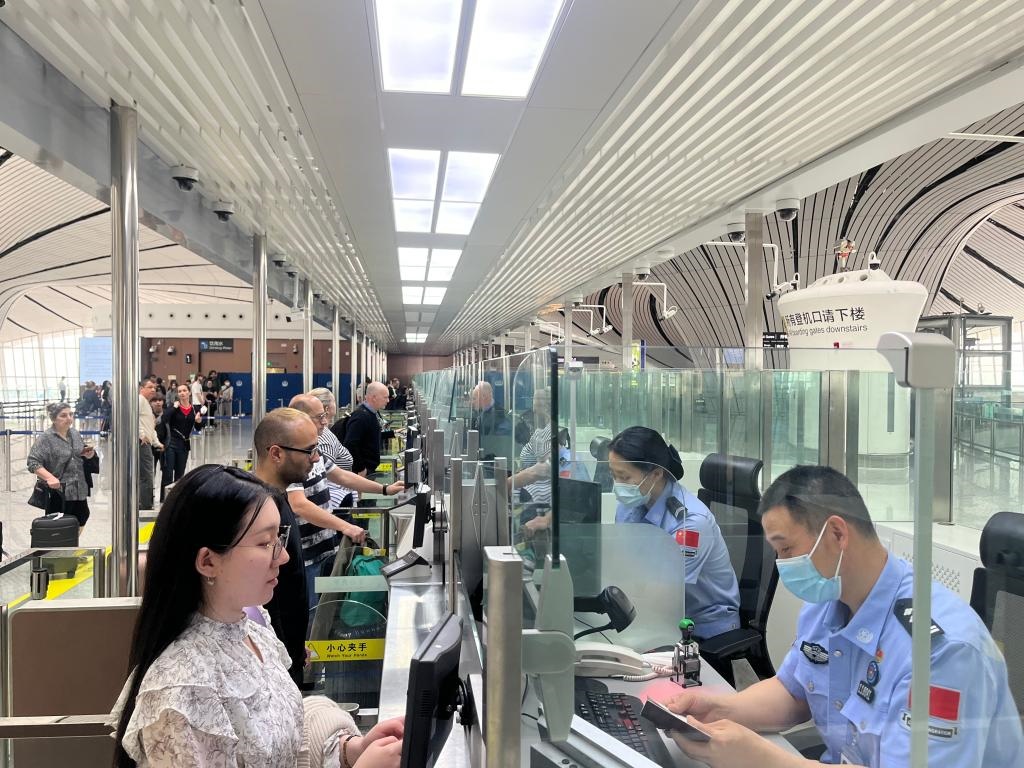 7月5日，北京大興國際機(jī)場邊檢站民警正在辦理邊檢查驗(yàn)手續(xù)。（北京大興國際機(jī)場邊檢站供圖）