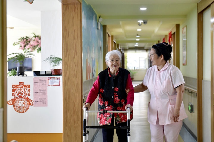 2024年5月25日，在山東省日照市東港區(qū)石臼街道日照幸福護(hù)理院，工作人員在陪護(hù)老人。新華社記者 郭緒雷 攝