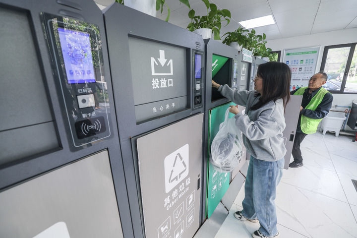 2024年4月10日，在浙江省湖州市吳興區(qū)飛英街道新華府小區(qū)內(nèi)，居民在垃圾分類智能系統(tǒng)的指導(dǎo)下進(jìn)行垃圾分類投放，居民的投放情況將實(shí)時匯總到智慧服務(wù)平臺，會有相應(yīng)的積分獎勵。新華社記者 徐昱 攝