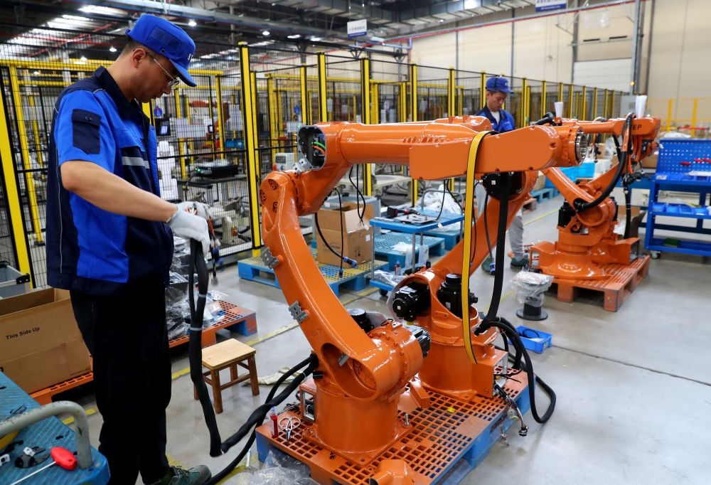 工作人員在上海新時(shí)達(dá)機(jī)器人有限公司位于嘉定的智能工廠內(nèi)忙碌（2024年5月23日攝）。新華社記者 龔兵 攝