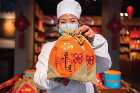在位于山西省晉中市平遙縣的平遙古城南大街的一家平遙牛肉店內(nèi)，工作人員展示一款牛肉產(chǎn)品（資料照片）楊晨光攝 / 本刊