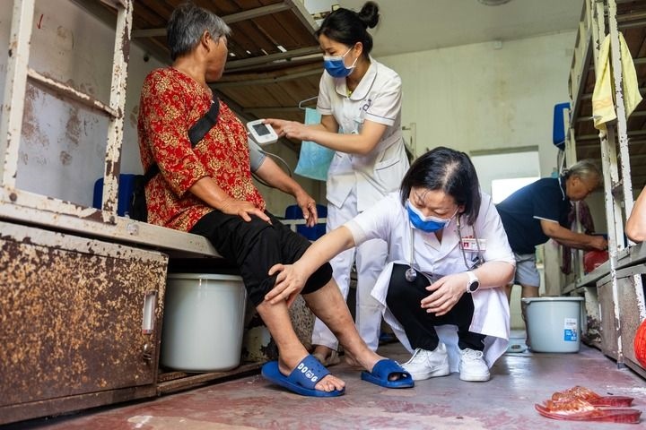 2024年7月30日，在湖南省湘潭縣河口中學(xué)安置點(diǎn)，醫(yī)務(wù)人員為受洪水影響而轉(zhuǎn)移安置的群眾檢查身體。 新華社記者 陳思汗 攝