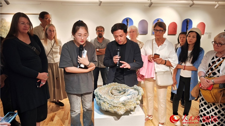 參展人、景德鎮(zhèn)陶瓷大學設計藝術學院副院長余劍峰（中）向來賓介紹參展作品。人民網(wǎng)記者 殷淼攝