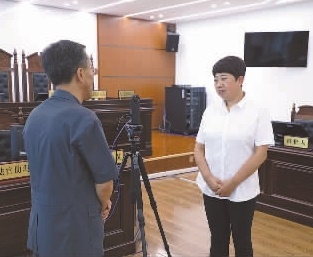 圖為全國人大代表玉明姬（右）詳細了解環(huán)境資源審判工作情況。劉思妤 攝
