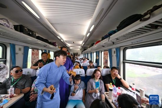 9月7日，相聲演員在S910列車上為旅客表演快板。