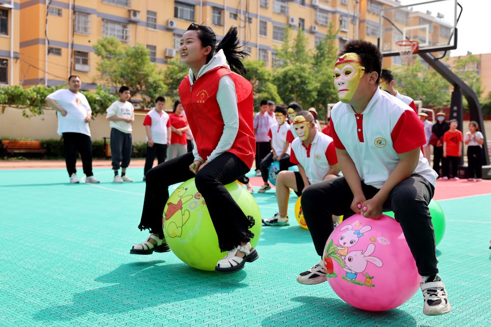 2024年5月17日，在山東省棗莊市市中區(qū)特殊教育中心，青年志愿者與智力障礙學(xué)生一起做游戲。新華社發(fā)（孫中喆攝）