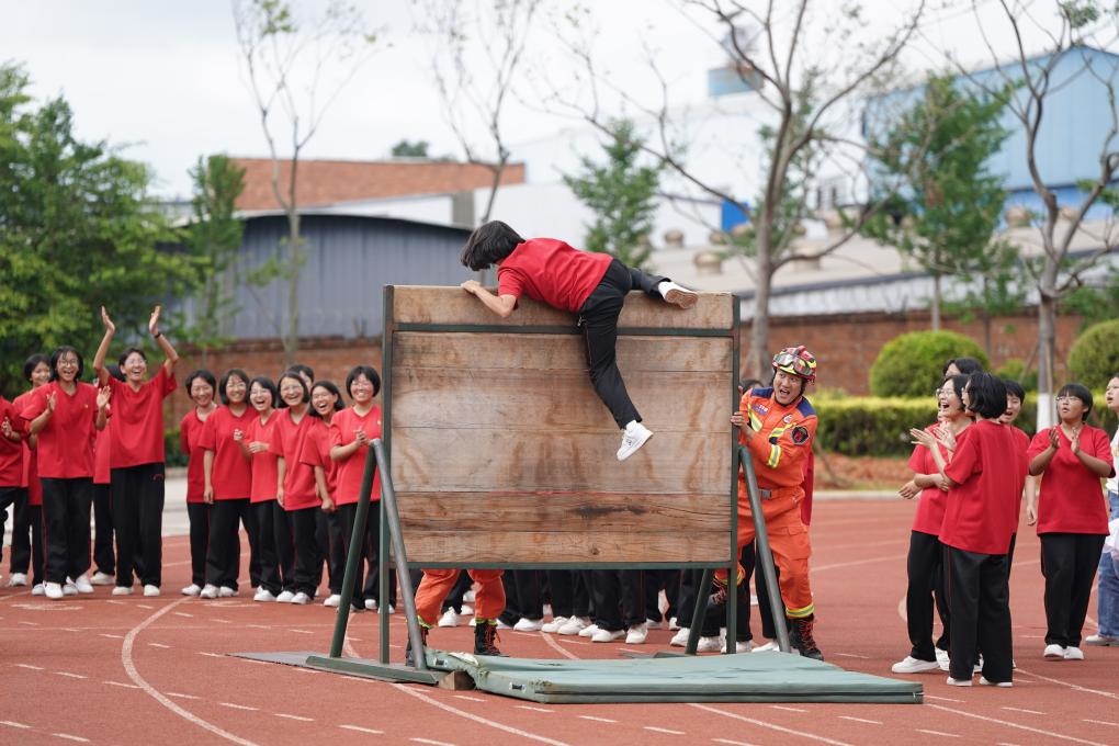云南麗江華坪女子高級中學(xué)學(xué)生在體驗翻越障礙板。新華社記者陳欣波 攝