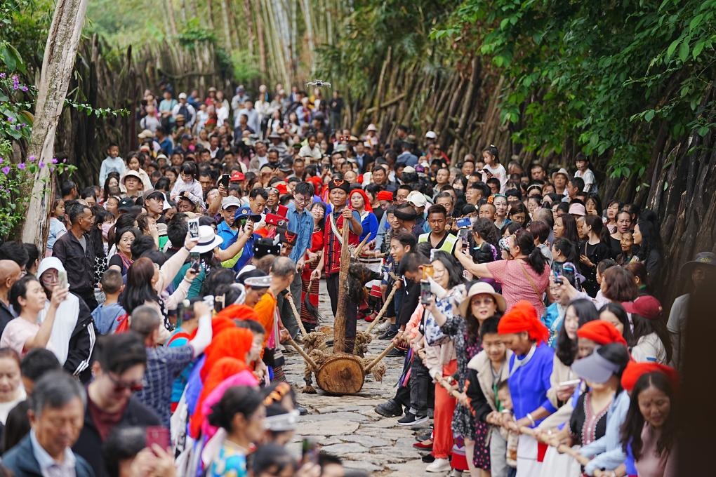 5月3日，各地游客在滄源縣翁丁村和村民一起參加佤族傳統(tǒng)民俗拉木鼓活動(dòng)。（滄源縣融媒體中心供圖）