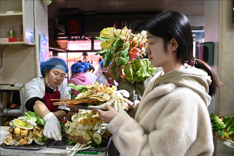 游客挑選好麻辣燙菜品后排隊(duì)等待加工。新華社記者 范培珅 攝
